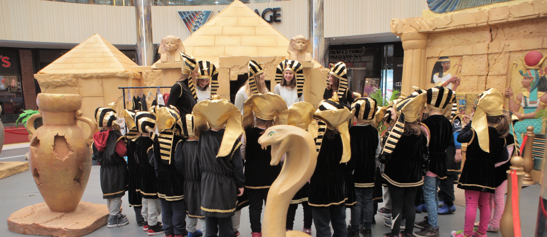The students of the kindergarten of mandoulides schools , wearing pharaoh hats and looking and listening to their teachers talking to them about ancient egypt