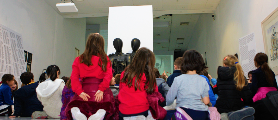 Παιδιά Δημοτικού με γυρισμένες πλάτες να κοιτάζουν αγάλματα στο Μακεδονικό Μουσείο Σύγχρονης Τέχνης