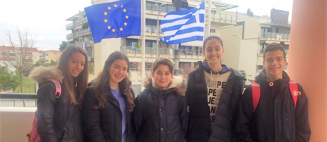 5 μαθητές ,3 κοριτσια και 2 αγόρια , μαθητές των εκπαιδευτηρίων, χαμογελούν στους αγώνες ΝΕ Γλώσσας
