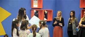 H συγγραφέας Τασούλα Τσιλιμένη δείχνει το βιβλίο της σε 3 μαθήτριες του δημοτικού των εκπαιδευτηρίων