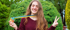 Η μαθήτρια των Εκπαιδευτηρίων Ά. - Χ. Σάββα φοράει το μετάλλιο της και χαμογελάει για τη συμμετοχή της στον Μαθηματικό Διαγωνισμό MYMC 2019